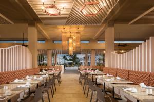 a dining room with long tables and chairs at Emotions by Hodelpa Puerto Plata in San Felipe de Puerto Plata