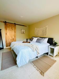 a bedroom with a large bed with a wooden door at Rancho 29 VDG in Ensenada