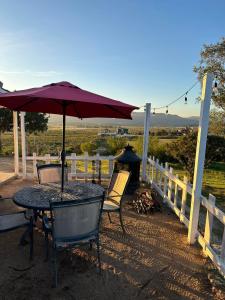 a table and chairs with an umbrella on a porch at Rancho 29 VDG in Ensenada +4 photos