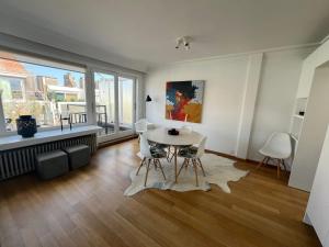 a living room with a table and chairs and a window at Amazing penthouse in Zoutelaan in Knokke-Heist
