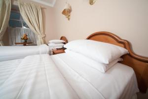 Darnley Lodge Hotel في Athboy: سريرين يجلسون بجانب بعض في غرفة النوم