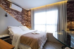 una camera da letto con un letto e una grande finestra di Studio Silva Jardim - Próx Shop Estação com VAGA a Curitiba