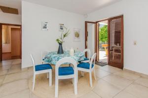 a white dining room with a table and chairs at House Kurta in Glavan
