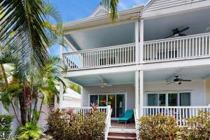 a white house with a porch and a balcony at Harbor Villa in Duck Key