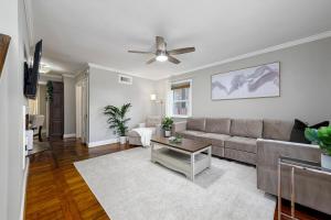 a living room with a couch and a ceiling fan at Cozy House, Pool Table and Parking, Mins to DC in Arlington
