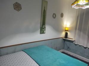 a bedroom with a bed with a green sheet on it at Casa Aloha Barra in Maricá