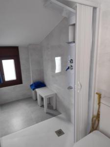 a white room with a bench and a window at Raíces de Alcalá in Alcalá del Júcar
