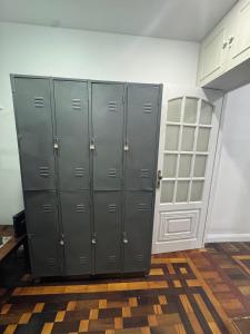 a locker room with gray lockers in a room at Quarto de Hóspedes a 3 min da praia in Rio de Janeiro