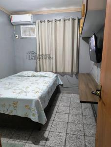 a small bedroom with a bed and a television at Condomínio Royal Park in Ananindeua +1 photo