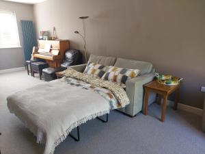 HindheadにあるSelf-contained 2-story accommodation in Grayshottのソファとテーブルのあるリビングルーム +2枚の写真