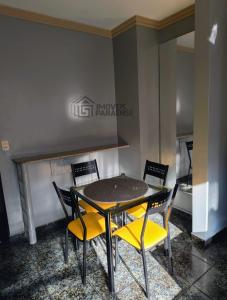 a dining room with a table and four chairs at Condomínio Royal Park in Ananindeua