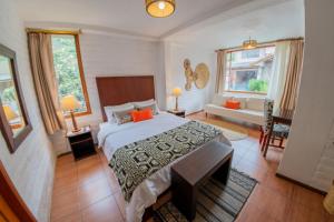 バーニョスにあるLa Floresta Hotelの大きなベッドとリビングルームのある寝室