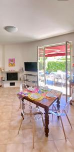 a dining room with a table and chairs and a patio at Appartamento Giardino Verde in Baveno