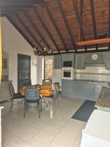 une cuisine avec des armoires vertes et une table et des chaises dans l'établissement Detached Villa with Stunning Mountain and Sea Views, 14m Pool & sunken Hot Tub, à Puerto del Carmen