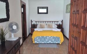 une chambre avec un lit avec une couverture jaune dans l'établissement Detached Villa with Stunning Mountain and Sea Views, 14m Pool & sunken Hot Tub, à Puerto del Carmen 22 autres photos