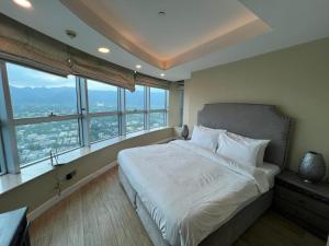 a bedroom with a large bed with large windows at Mountain View Luxury Centaurus Mall Apartment Islamabad in Islamabad