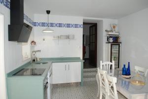 a kitchen with a sink and a table with chairs at La Casa de Antonina in Castilblanco de los Arroyos