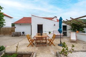 a patio with a table and chairs and an umbrella at Casa Alba, desde 1926 in Alvados