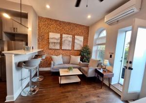 Una sala de estar con un sofá y una pared de ladrillos. en Studio w Terrace - Street Parking -10 min to DT, en Filadelfia