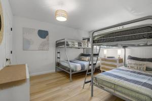 a bedroom with two bunk beds and a lamp at Lakeview Retreat Modern 2BR Condo on Newfound Lake in Bristol