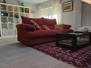 a red couch in a living room with a table at Apartamento Riazón3 in Ourense