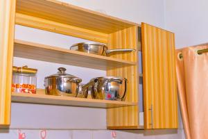 a kitchen with wooden shelves with pots and pans at Haven Homes in Nakuru +19 photos