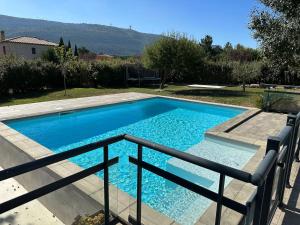 a swimming pool with blue water in a yard at Le LODGE De La Sainte Baume in Plan dʼAups