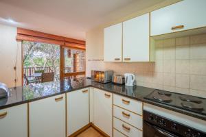 ヘイジービューにあるKruger Park Lodge Unit 526の白いキャビネットと窓のあるキッチン