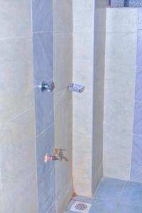 a shower stall with aaucet in a bathroom at Haven Homes in Nakuru