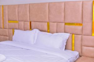 a bed with white sheets and pillows in a room at Haven Homes in Nakuru
