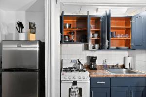 een keuken met een fornuis, een wastafel en blauwe kasten bij Perfect Cozy Studio in Center City with Fast WiFi in Philadelphia +3 foto's