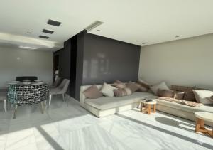 a living room with a couch and a table at Luxury Stay in Prestigia Golf City in Bouskoura