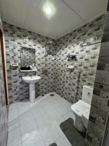 a bathroom with a toilet and a sink at Ilé Ifè in Cotonou