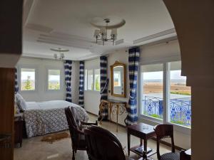 スコイラにあるInstant Saisons - Ferme d'hôtesのベッドとテーブルと椅子のある寝室