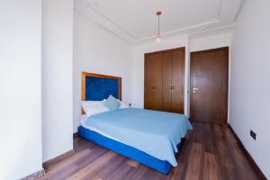 a bedroom with a blue bed and wooden cabinets at Jack Beach Bay in Tamaris +10 photos