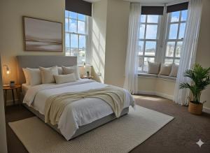 a bedroom with a large white bed with windows at 2 Bed Apartment in Brighton with Side Sea View in Brighton & Hove