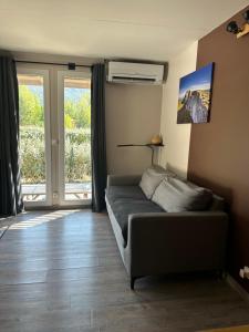 a living room with a couch in front of a window at Le LODGE De La Sainte Baume in Plan dʼAups +23 photos