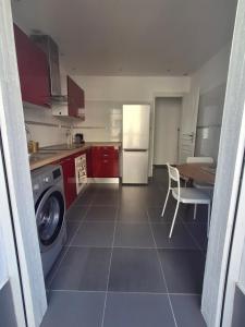 a kitchen with a washer and a table and a refrigerator at Joli T1 bis - Centre ville in Bastia