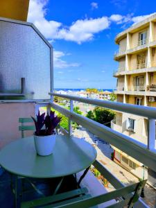 a table on a balcony with a view of the ocean at Joli T1 bis - Centre ville in Bastia +3 photos