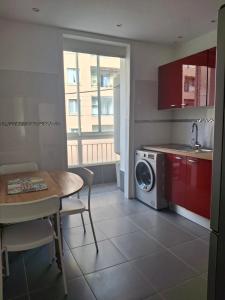 a kitchen with a table and a washing machine at Joli T1 bis - Centre ville in Bastia
