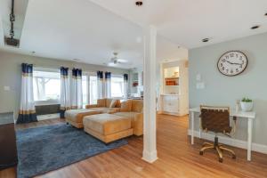 ein Wohnzimmer mit einer Couch und einer Uhr an der Wand in der Unterkunft Pets Welcome Beachfront Family Retreat in Norfolk in Willoughby Beach