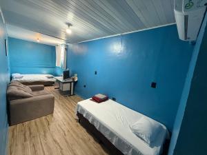 a bedroom with blue walls and a bed and a couch at Hotel e Restaurante Casa Paraense Original, px ao aeroporto in Manaus +80 photos