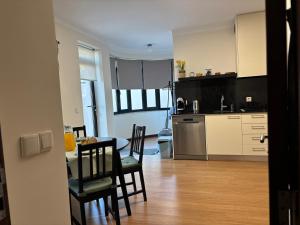 una cucina e una sala da pranzo con tavolo e sedie di B Apartamentos Castelo a Viana do Castelo
