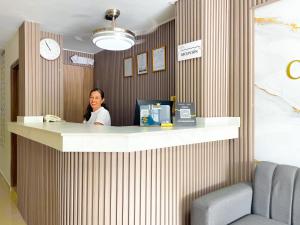 a woman sitting at a counter in an office at Hotel Caribe Real Inn in Santa Marta