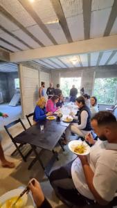 a group of people sitting around a table eating food at Ayur nidhi Eco Hostel in Petrópolis
