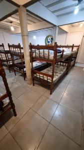a room with three wooden bunk beds on a tile floor at Ayur nidhi Eco Hostel in Petrópolis +35 photos