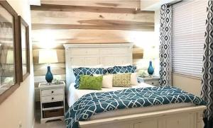 a bedroom with a bed with blue and green pillows at Sunny First-Floor Condo in Bonita National with Golf & Social Membership Ideal 30-Night Stay in Bonita Springs