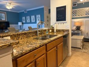 a kitchen with a sink and blue walls at Sunny First-Floor Condo in Bonita National with Golf & Social Membership Ideal 30-Night Stay in Bonita Springs