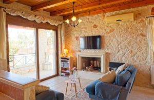 a living room with a couch and a fireplace at Villa Petalouda in Tragaki