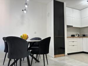 リヴノにあるAmare Apartmentのダイニングルーム(テーブル、黒い椅子付)